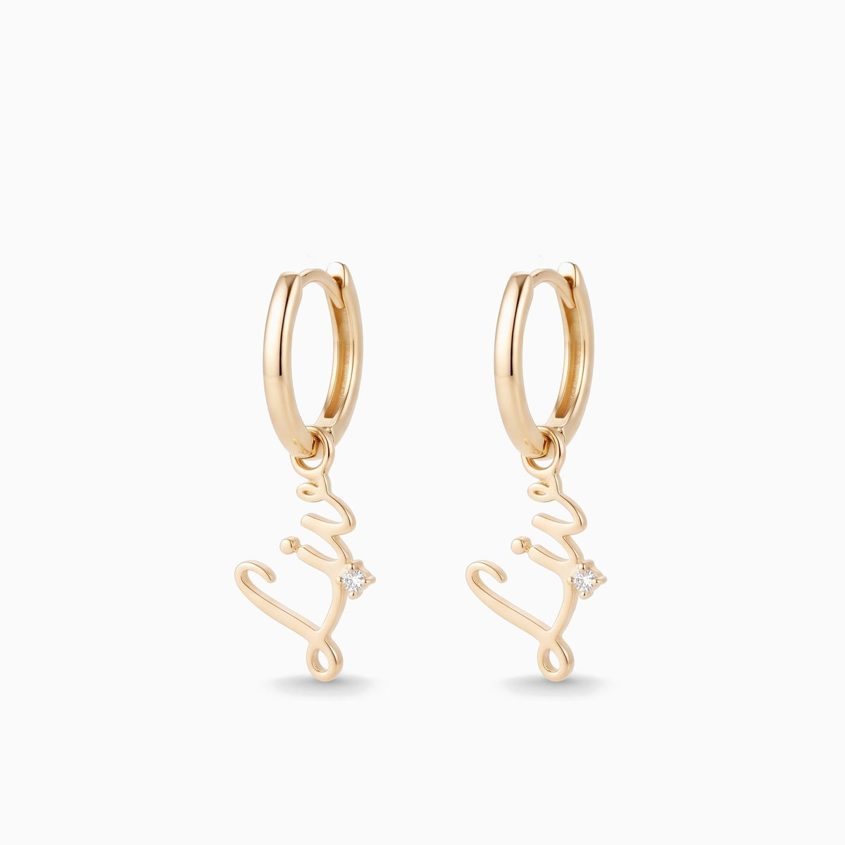 Gold huggie hoop earrings with a script name charm and a tiny stone