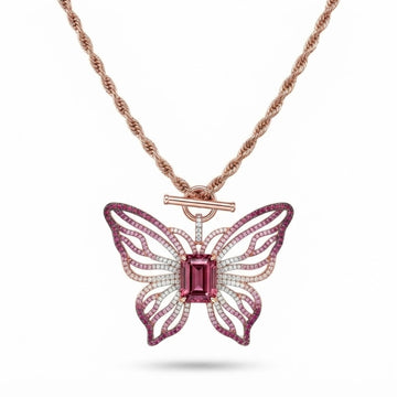 Pink open-work butterfly pendant with emerald-cut pink center stone on a rose gold rope chain with toggle clasp